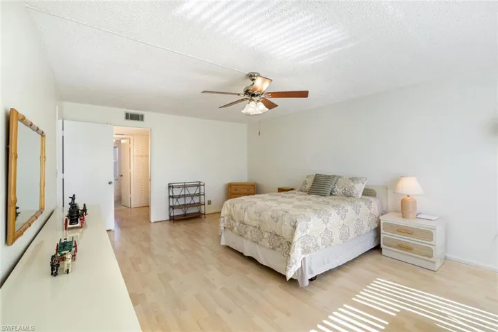 Bedroom featuring light wood finished floors, a textured ceiling, and a ceiling fan