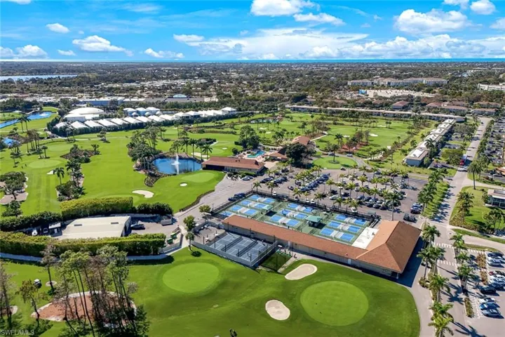View of property location featuring a golf course, a large body of water, and nearby suburban area