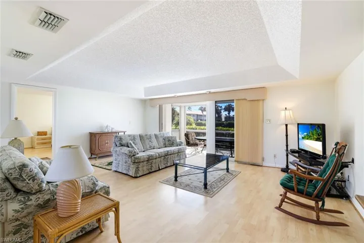 Living area with a textured ceiling and light wood-style flooring