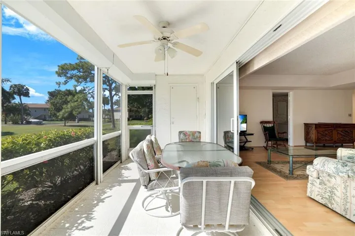 Sunroom / solarium with a ceiling fan and outdoor dining area