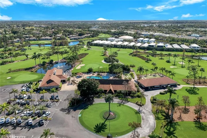Aerial perspective of suburban area featuring a local golf course and a nearby body of water