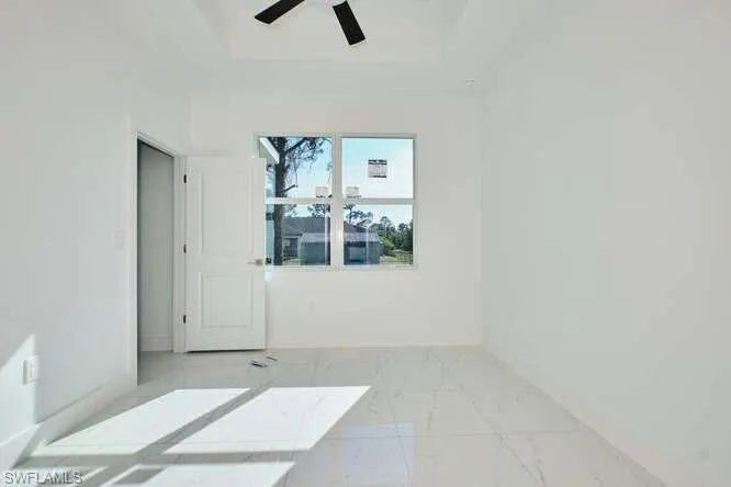 Unfurnished room featuring light marble finish floors and baseboards