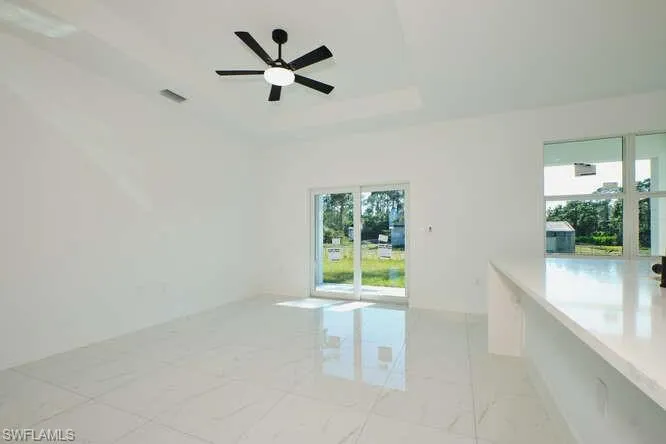 Unfurnished room with a raised ceiling and ceiling fan