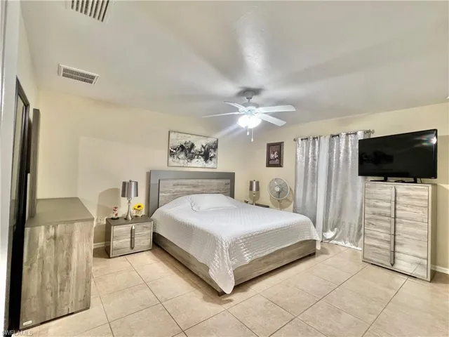 Bedroom with light tile patterned flooring and ceiling fan