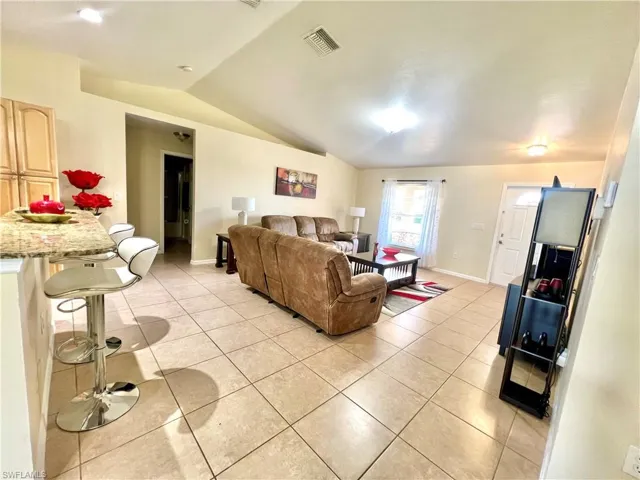 Living area featuring vaulted ceiling and light tile patterned floors