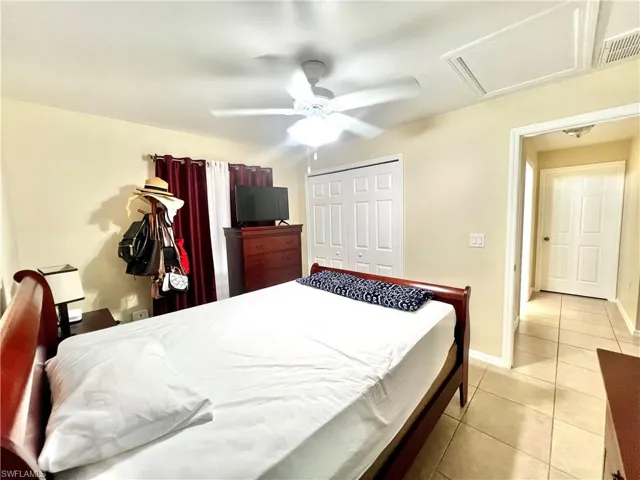Bedroom with light tile patterned flooring, a closet, and a ceiling fan