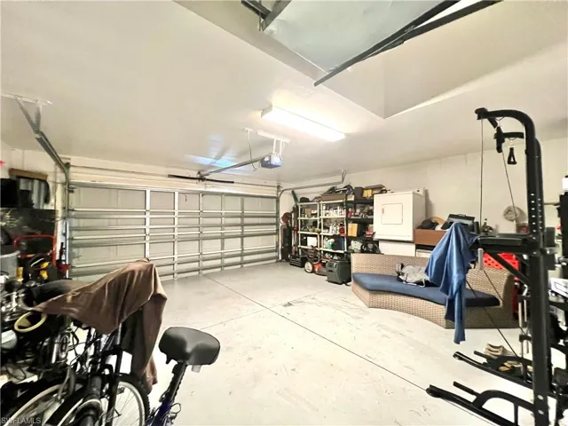 Garage featuring a garage door opener and washer / dryer