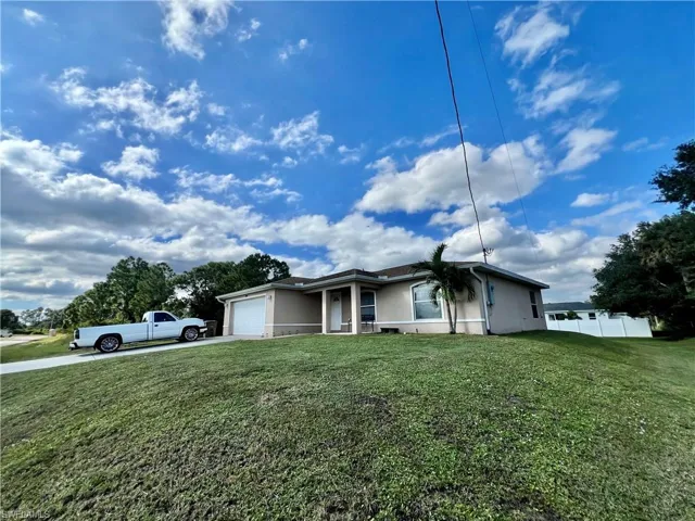 View of front of home with stucco siding, driveway, and an attached garage