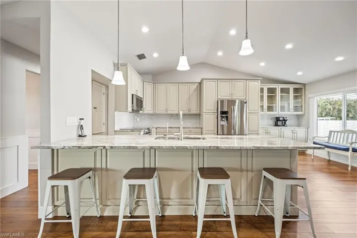 Kitchen featuring an expansive island with a light-colored countertop, pendant lighting, and recessed ceiling lights