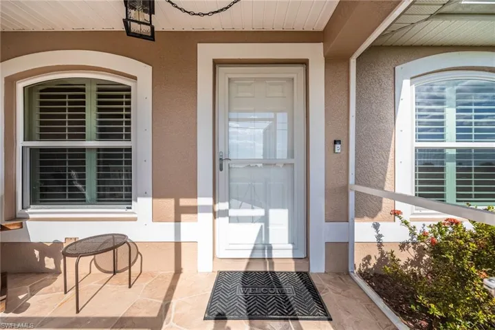 The property features an inviting front entryway with a white door and decorative sidelight windows, complemented by a textured wall finish