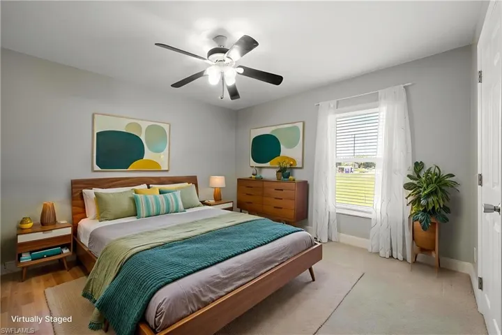STAGED 2nd Bedroom featuring light gray walls, a window with horizontal blinds and sheer curtains, and a ceiling fan with integrated lighting