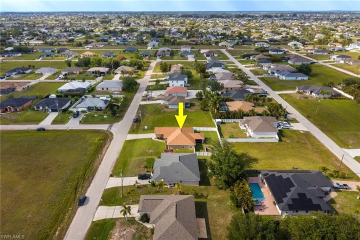 Aerial view of the property, showcasing its location within a residential neighborhood with paved streets