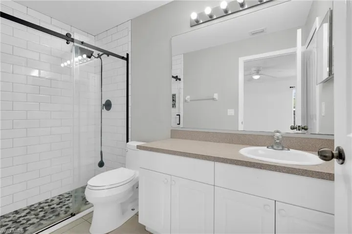 Bathroom with a shower stall, vanity, and light tile patterned floors