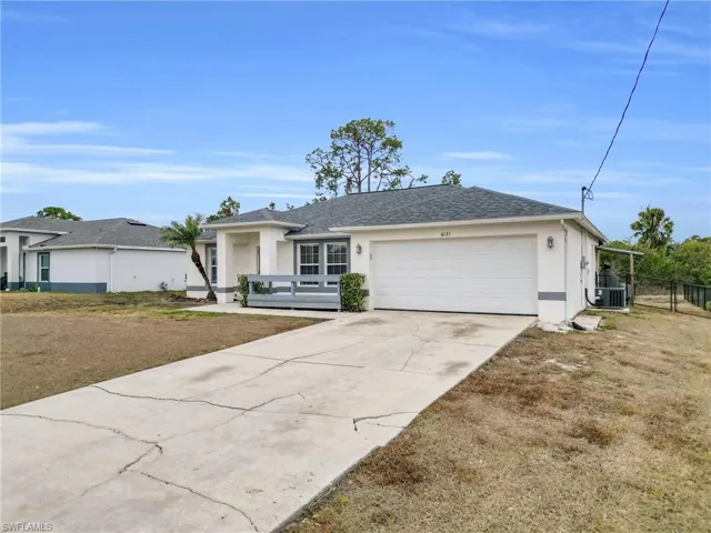 Ranch-style house with stucco siding, an attached garage, concrete driveway, and a shingled roof