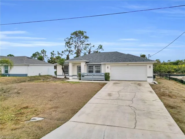 Single story home featuring stucco siding, driveway, an attached garage, and roof with shingles