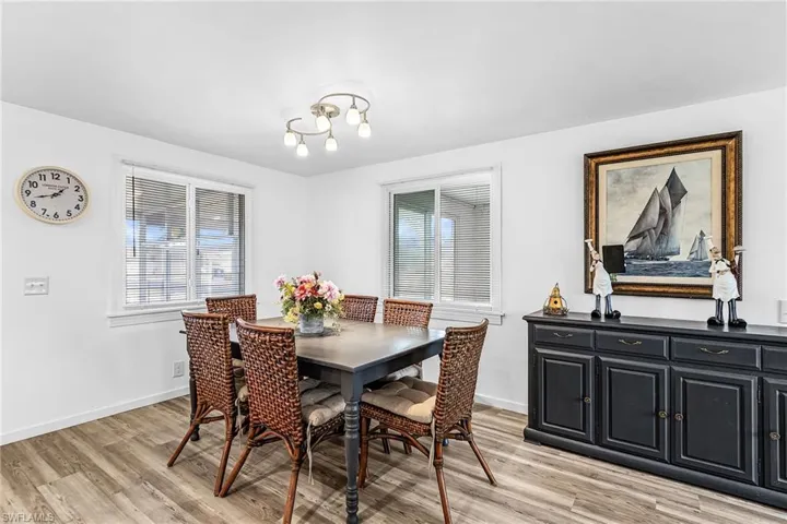 Dining area featuring wood-finish flooring, white walls, and a contemporary ceiling light fixture