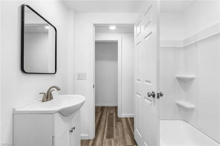 White vanity with an integrated sink and brushed nickel faucet