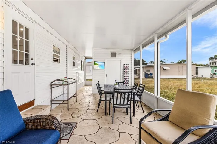 Screened porch featuring a patterned concrete floor, white siding exterior, and a white ceiling