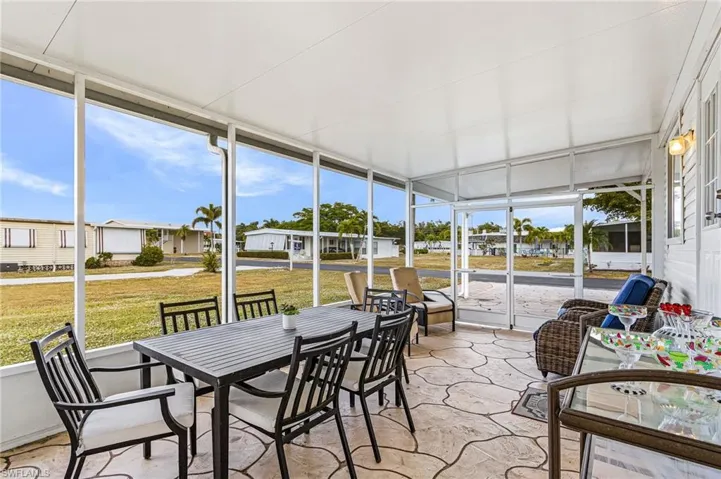 Screened patio featuring an expansive concrete patio with irregular flagstone pattern, a white aluminum frame, and a solid white ceiling