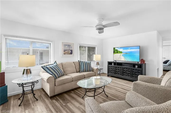 Spacious interior featuring wood-finish flooring, white walls, and a ceiling fan