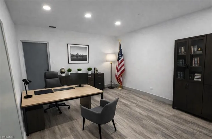 Office space featuring light wood-style floors and recessed lighting