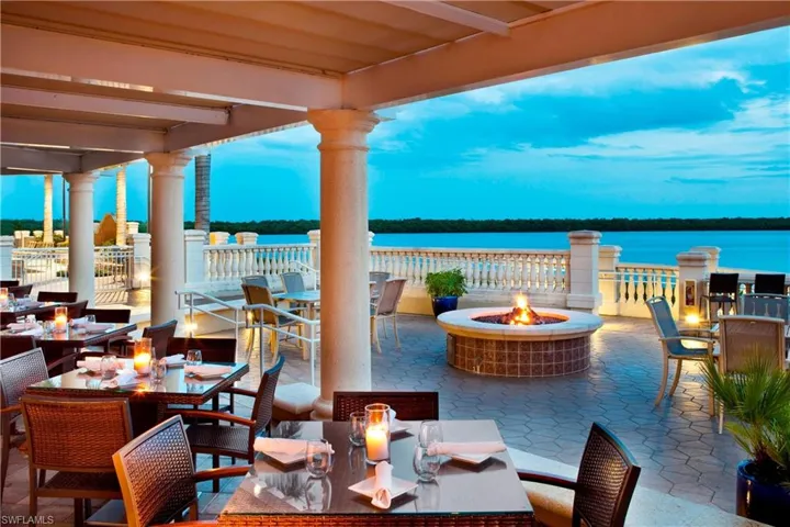 View of patio featuring outdoor dining space, a water view, and a fire pit
