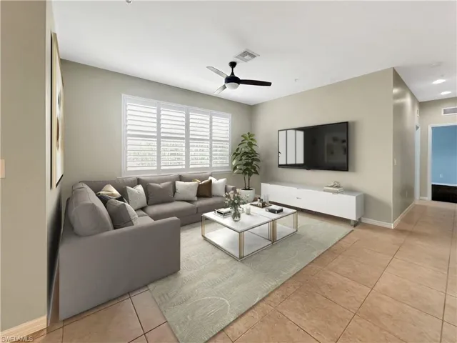 Virtually Staged - Living room featuring ceiling fan, light tile patterned floors, and baseboards