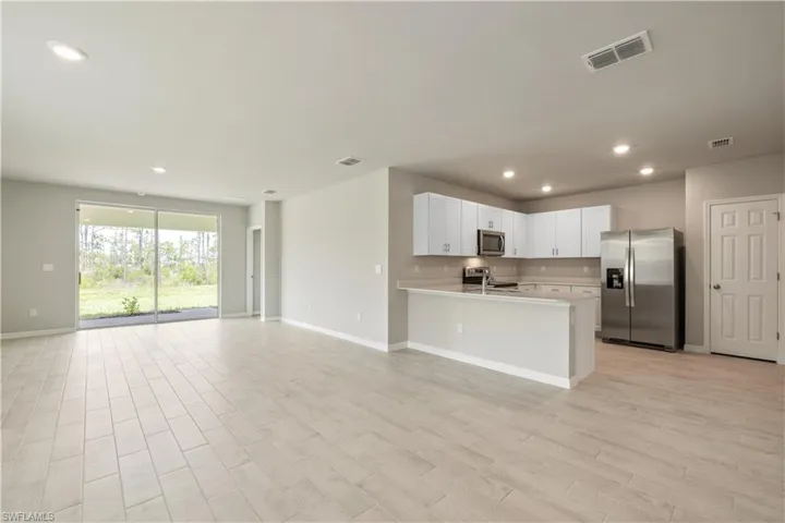 Kitchen featuring white cabinetry, kitchen peninsula, and stainless steel appliances