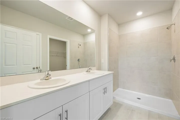 Bathroom with a tile shower and double sink vanity