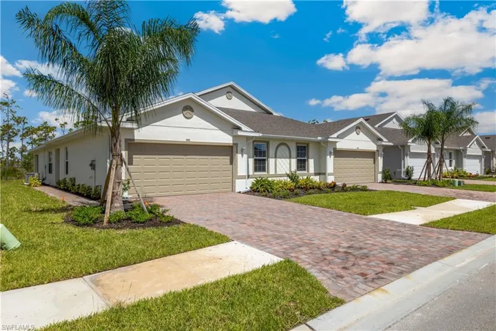 Ranch-style home with a garage and a front lawn