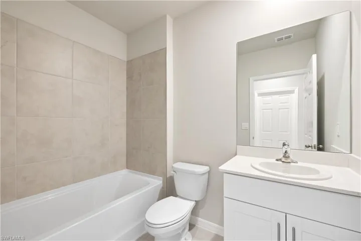 Full bathroom with vanity, toilet, and tiled shower / bath