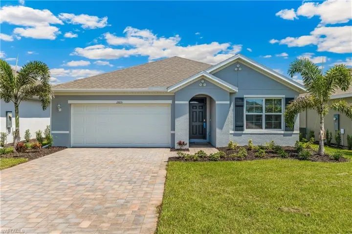 Ranch-style house featuring stucco siding, decorative driveway, an attached garage, and a front lawn