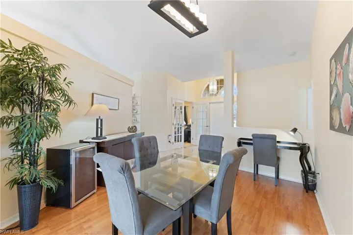 Dining area featuring wood-finish flooring, a contemporary linear chandelier, and light-toned walls