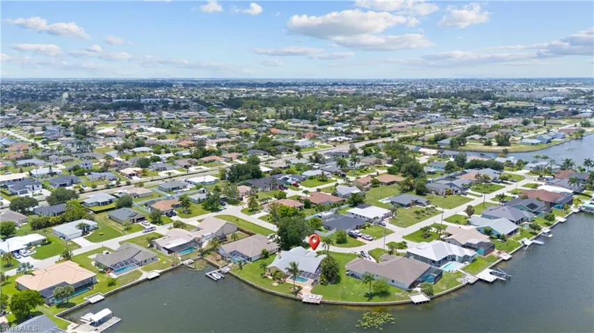 Waterfront property featuring a private boat dock, in-ground swimming pool, and concrete patio