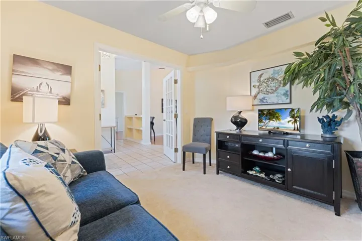 Cream-toned walls accenting a carpeted room with a ceiling fan and crown molding