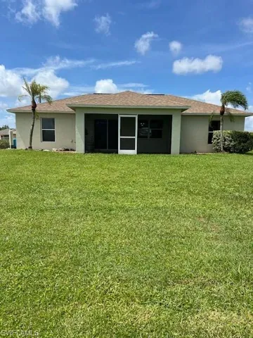 Rear view of property with a lawn