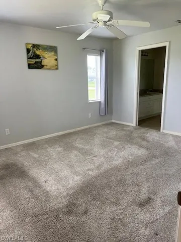 Carpeted empty room featuring ceiling fan