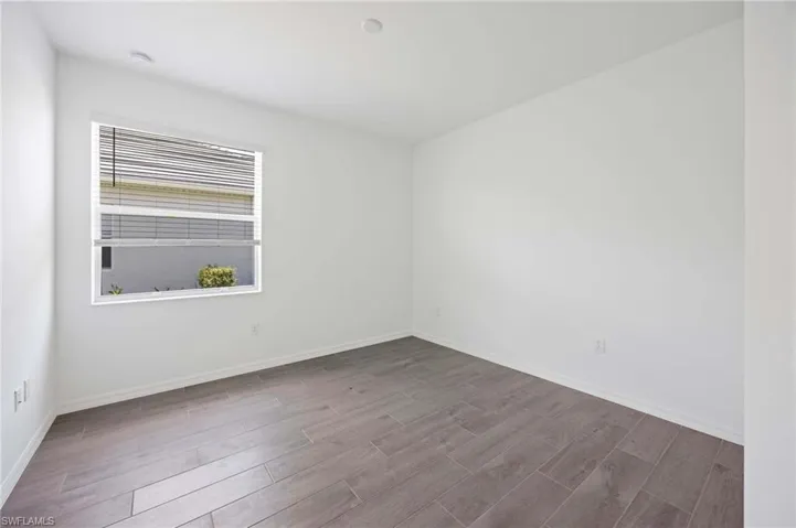 Empty room featuring baseboards and wood finished floors