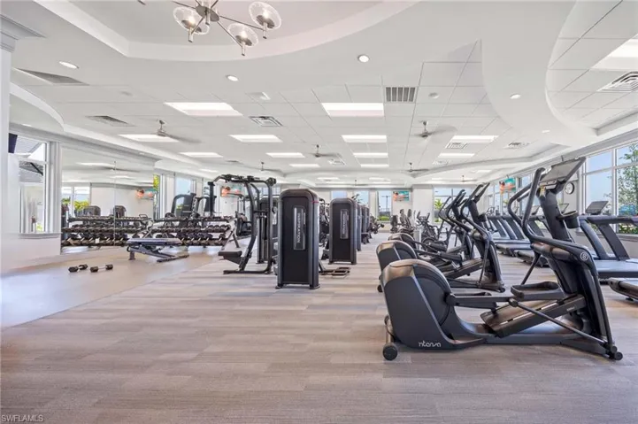 Exercise room featuring visible vents, carpet flooring, and a chandelier