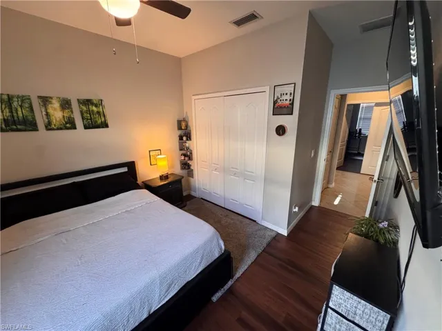 Bedroom featuring dark wood-style flooring, a closet, and ceiling fan