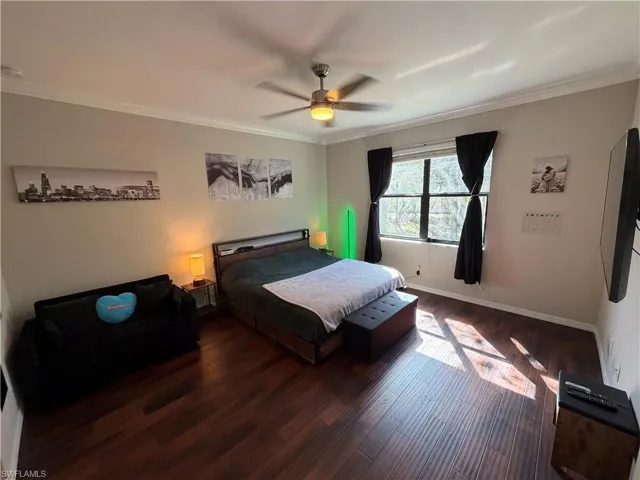 Master bedroom with hardwood / wood-style flooring, ornamental molding, and ceiling fan