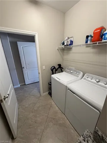 Laundry area with washing machine and clothes dryer and baseboards