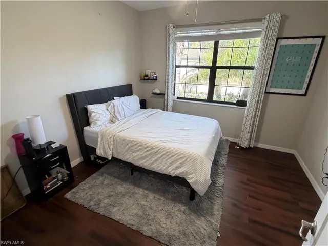 Bedroom with baseboards and dark wood-style floors