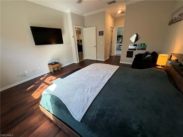 Master Bedroom with dark wood-style flooring, crown molding, and a ceiling fan