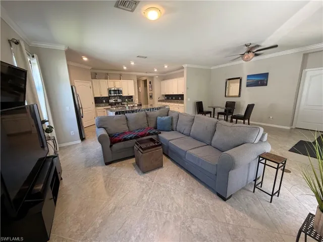 Living room with crown molding and ceiling fan