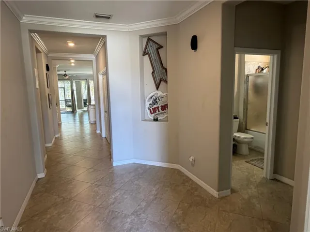 Hallway featuring ornamental molding and baseboards