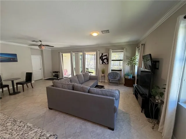 Living area featuring ornamental molding and a ceiling fan
