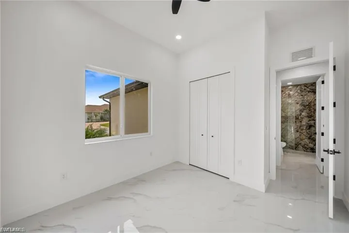 White tile flooring, recessed lighting, white double-door closet, and a window providing natural light