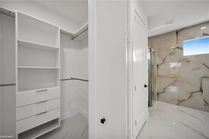 Walk-in closet with built-in shelving and drawers