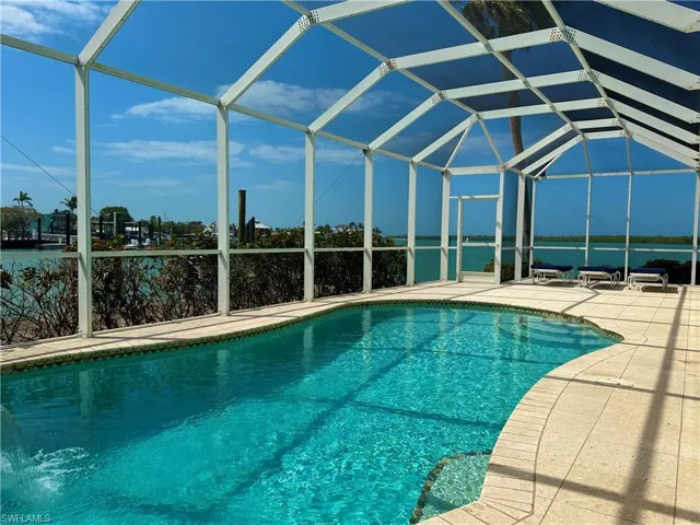 NASSAU-built swimming pool and spillover waterfall with  a loveseat in the deep end..
